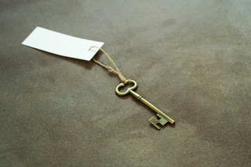 Old vintage brass key with white tag