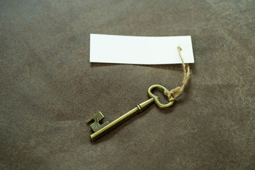 Old vintage brass key with white tag