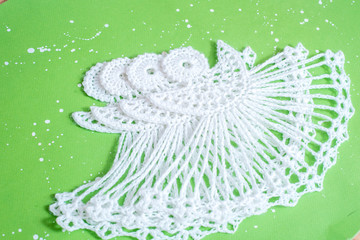 White crocheted Christmas angel from threads on a blue background. New Years winter card. Handmade and creativity. Crochet, measurement with a ruler. cozy new year. flat lay.Creative Handmade.