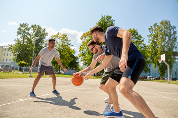 sport, leisure games and male friendship concept - group of men or friends playing street basketball