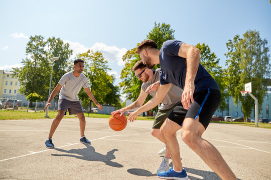 Sport, Leisure Games And Male Friendship Concept - Group Of Men Or Friends Playing Street Basketball