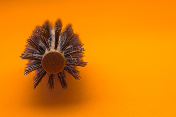 Hairbrush on orange background