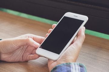 A hands holding mobile smart phone in coffee cafe