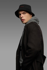 Medium close-up shot of a short-haired European man dressed in a gray hooded top, a black jacket...