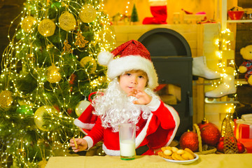 Fototapeta na wymiar Christmas for kid. Santa Claus enjoys cookies and milk left out for him on Christmas eve. Santa fun. Funny child Christmas.