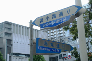 京都駅前のビルディングと烏丸通りと塩小路通りの交通標識の案内板