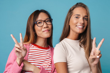 Portrait of multinational pretty women smiling and gesturing peace sing