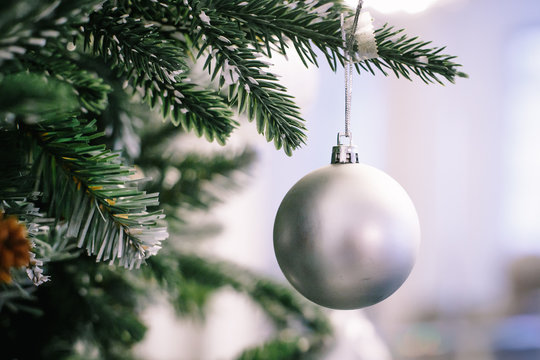 Christmas tree branch decorated with silver balls and white decor