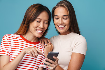Portrait of multinational beautiful women smiling and using cellphone