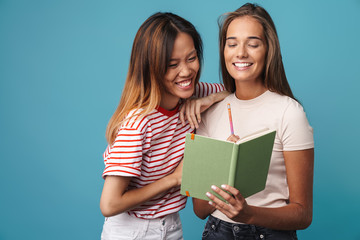 Portrait of laughing women holding and looking at exercise book
