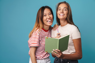 Portrait of happy women holding exercise book and laughing