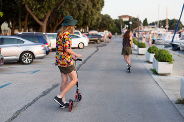 Young people ride on scooter at the waterfront