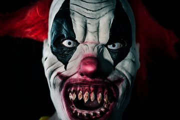 scary evil clown with a bloody mouth