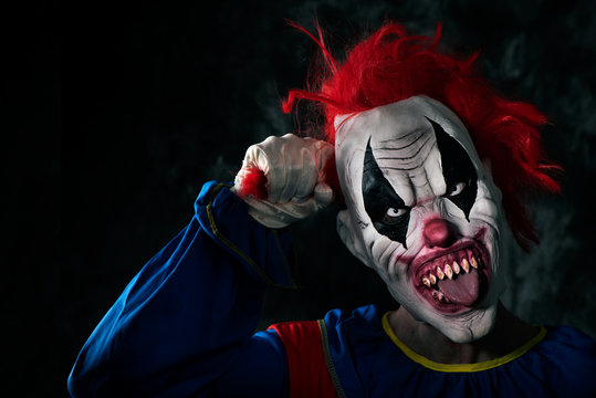 scary evil clown sticking out his tongue