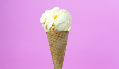 Closeup Vanilla ice cream scooped in waffle cone on pink background, Closeup Front view Food concept.