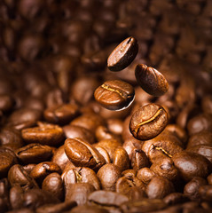 Roasted coffee beans. Seeds of freshly roasted coffee with smoke. Coffee beans closeup with emphasis on the grain with smoke.