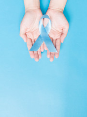 Men's health and Prostate cancer awareness campaign concept. Man hands holding light blue ribbon...