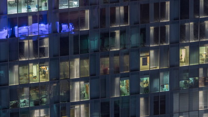 Night view of exterior apartment tower timelapse. High rise skyscraper with blinking lights in windows