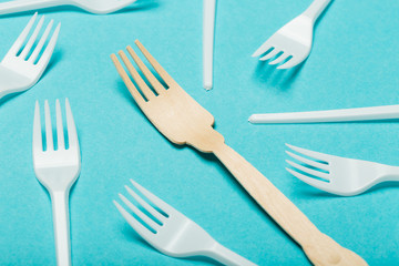 Eco-friendly dishes, wooden and plastic forks on a blue background