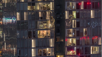Night view of exterior apartment tower timelapse. High rise skyscraper with blinking lights in windows