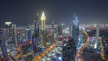 Fototapeta premium Skyline of the buildings of Sheikh Zayed Road and DIFC aerial night timelapse in Dubai, UAE.