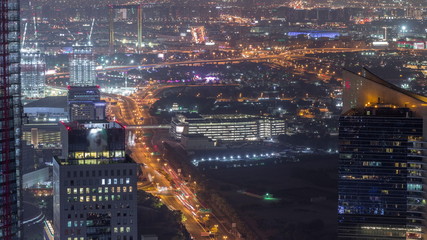 Aerial view to financial and zabeel district night timelapse with traffic and under construction building with cranes from downtown