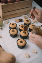 The baker creates cupcakes in molds. Filling biscuits with homemade liquid caramel