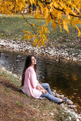 Girl with long brown hair in autumn park.