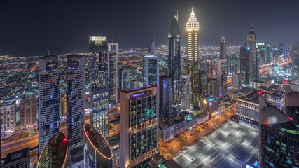 Naklejka premium Skyline of the buildings of Sheikh Zayed Road and DIFC aerial night timelapse in Dubai, UAE.