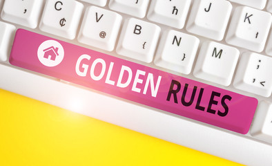 Writing note showing Golden Rules. Business concept for basic principle that should always follow to ensure success White pc keyboard with note paper above the white background