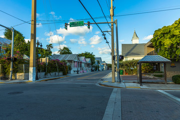 View of one of streets of Key West. Old houses and big green trees on blue sky background. Key West. Florida. USA. 