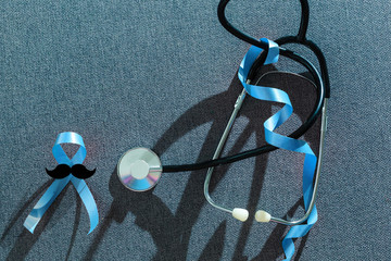 Blue ribbon on light blue background mustache banner representing an annual event during the month...
