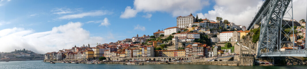 Panoramic view of the Douro River snaking through the city of Porto with the Ponte Luiz bridge in the foreground taken at a low level.