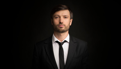 Portrait Of Serious Businessman Looking At Camera, Black Background