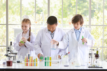 happy kids making science experiments. (education and scientist concept)