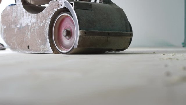 sanding a wooden floor with a grinder
