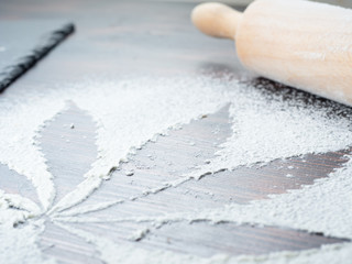 cooking cannabis food. Trail of cannabis leaf on white flour. on a wooden table
