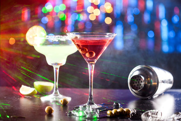 Two glasses with alcoholic drinks on a bar