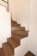 wooden staircase in white room .