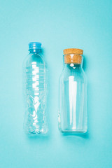 plastic and glass bottles for water on a blue background, an alternative