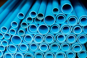 Close up to blue plastic pipe background, PVC pipes stacked in warehouse,  PVC water pipes used for construction.