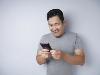 Young Man Texting Reading Chatting on His Phone, Smiling Happy