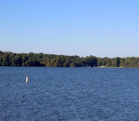 The waves and ripples in the water of the calm lake.