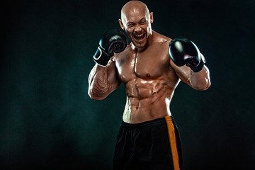 Sportsman, man boxer fighting in gloves on black background. Fitness and boxing concept. Action...