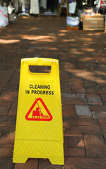 Closeup of janitorial, cleaning equipment on vintage brick walkway. Vertical view.