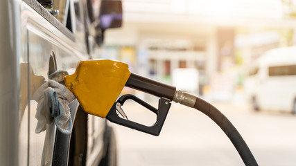 fuel nozzle and car on gas station .Vehicle fueling facility at petrol station. Transportation and...