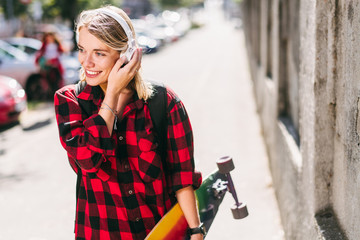 Young skater girl with headphones posing 
