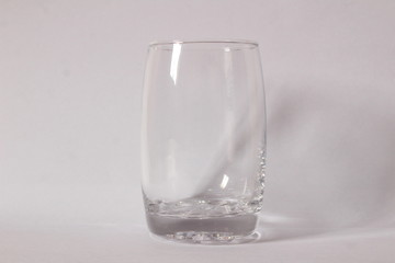 Single empty transparent / white glass with white background and shadow