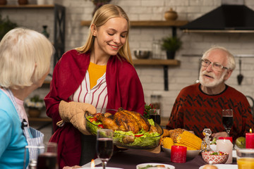 Daughter is bringing the delicious turkey at the table