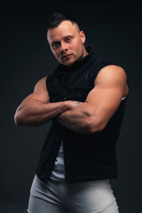 Fototapeta na wymiar Strong and handsome young man with muscles and biceps. Studio shooting on black background.
